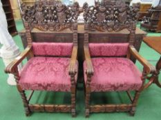 2 oak open armchairs with highly ornate carved backs depicting animals, figures, scrolls (known as