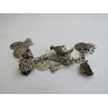 Silver charm bracelet with 11 silver charms, weight 1.4ozt. Estimate £20-30.