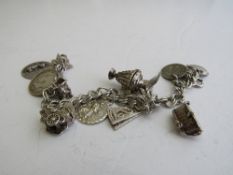 Silver charm bracelet with 11 silver charms, weight 1.4ozt. Estimate £20-30.