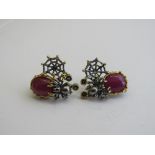 Hannah May ruby & sapphire silver earrings, decorated with a spider & web. Estimate £150-200.