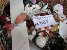 A basket containing costume jewellery. Estimate £15-20.