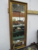 Gilt framed bevel edge wall mirror, 135cms x 50cms. Estimate £30-50.