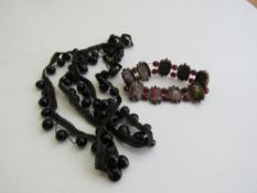 A braid & jet bead necklace & a bracelet of coloured glass & red beads. Estimate £20-30.