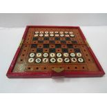 Red leather bound case containing chess board & travelling chess set.