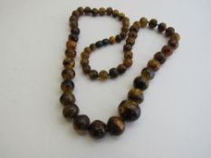 Gold & speckled amber necklace. Estimate £100-150.