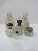 2 cut glass decanters, height 15cms, 3 glass centre bottles & a silver topped glass powder jar.