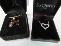 Gold coloured necklace & earring set with red stone & a silver heart shaped necklace. Estimate £10-