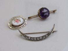 Large purple stone set in gold coloured metal, diameter 1.8mm; a crescent shaped white metal