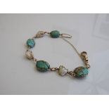 9ct gold wire bracelet set with 4 green stones & 3 mother of pearl. Estimate £30-50