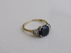 18ct gold ring set with a large sapphire with diamond on either shoulder, size P, weight 3.9gms.