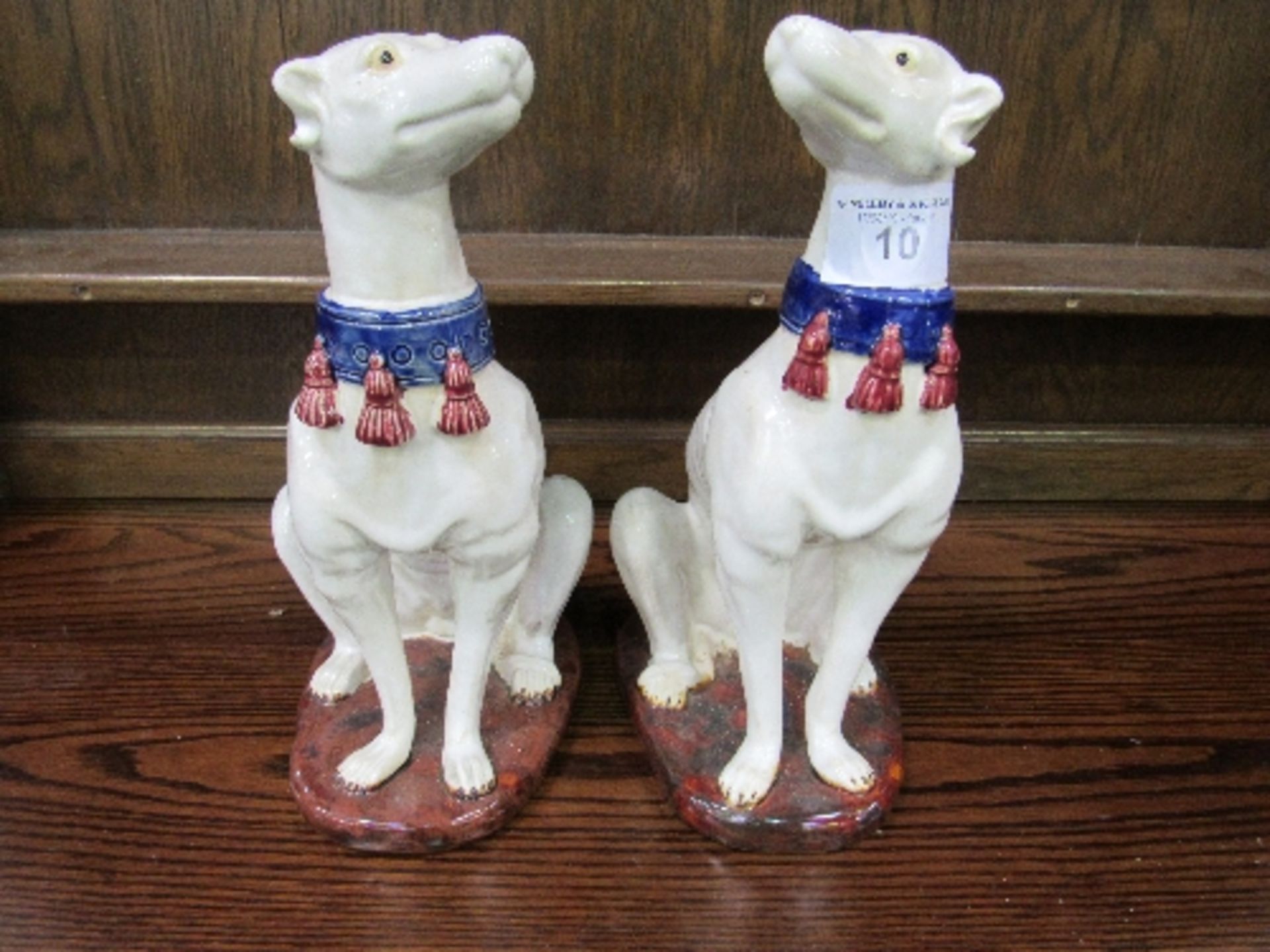 Pair of Majolica greyhound figures painted white with blue collars, height 36cms. Estimate £50-80