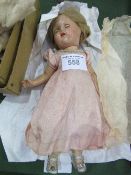 Bisque doll with opening & closing eyes, blonde hair, pink silk dress & a boxed artificial flower