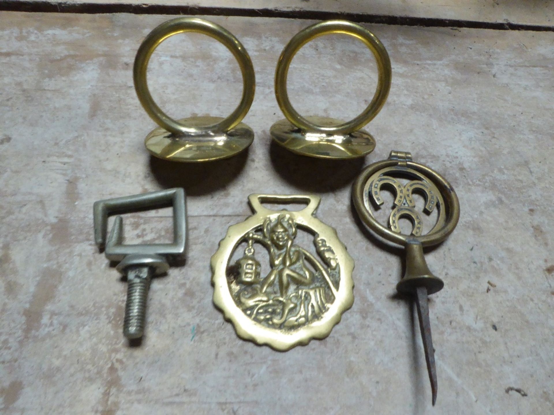 Two brass rein terrets, a swinger, a Pixie horse brass and a whitemetal terret
