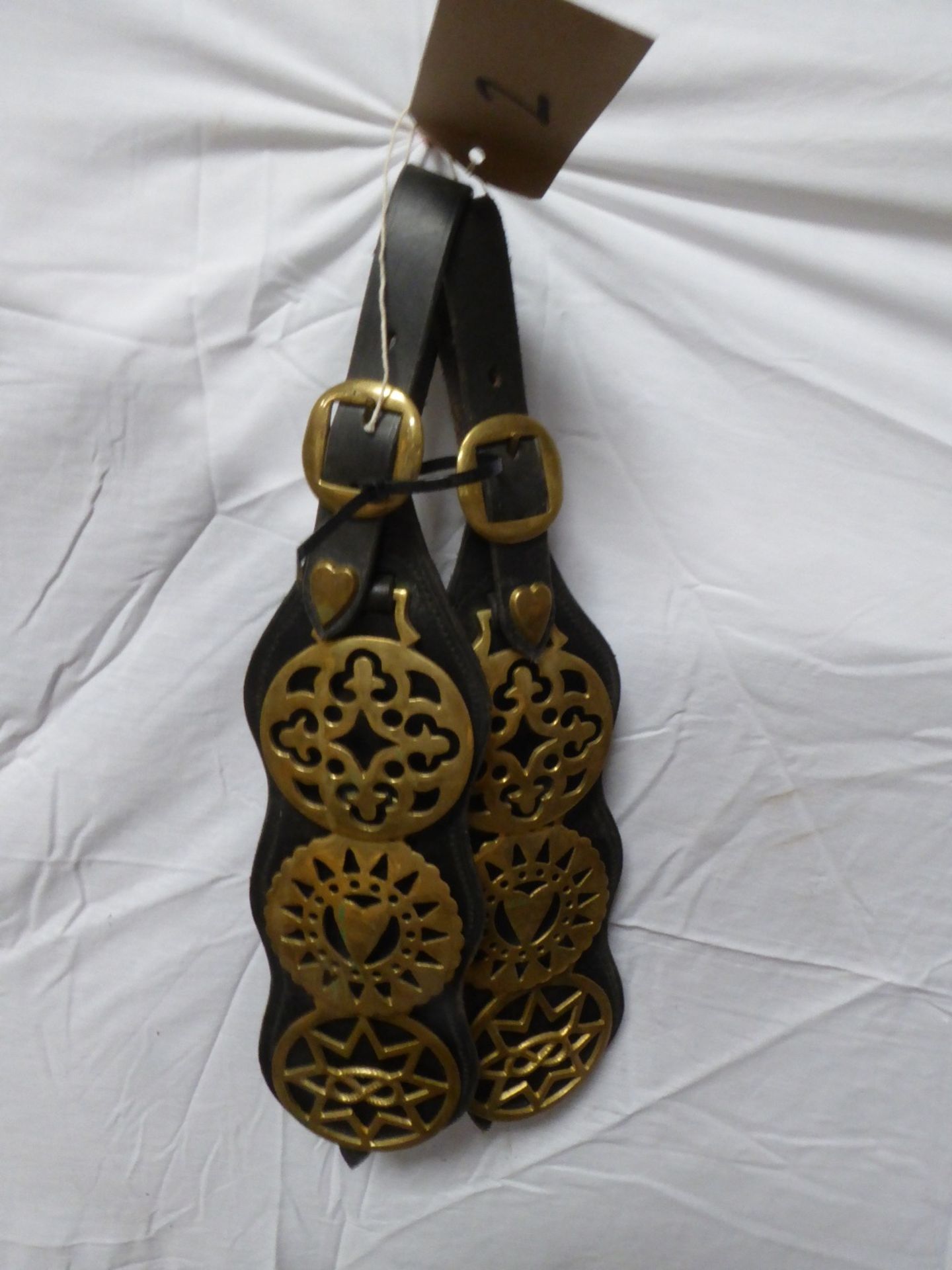 Pair of leather martingales each with three horse brasses and decorated with heart studs.