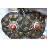 Pair of circular leathers each edged with 12 brass hearts and a central brass ship's wheel with a