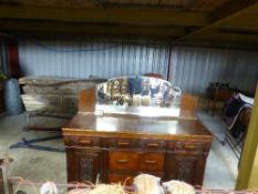 A mahogany sideboard with carved drawer fronts and panels with mirrored back