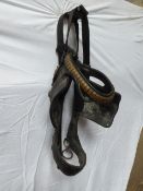 Old black leather cart bridle with brass clincher brow band and studs on the blinkers