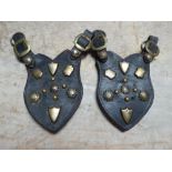 Pair of shaped leathers each with various brass studs and buckle