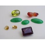 Oval shaped yellow stone, 2.4cms x 1.5cms x 1.3cms; large dark purple stone, 2cms x 1.6cms x 0.9cms;