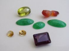 Oval shaped yellow stone, 2.4cms x 1.5cms x 1.3cms; large dark purple stone, 2cms x 1.6cms x 0.9cms;