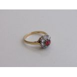 18ct gold ring set with a single red stone & surround by diamonds, size N, weight 3.6gms.
