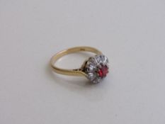 18ct gold ring set with a single red stone & surround by diamonds, size N, weight 3.6gms.
