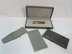 Christian Dior gold plated cigarette lighter in original box. Estimate £50-70