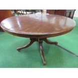 Mahogany circular tilt-top table on heavy turned column to 3 scrolled feet with caster, 122cms