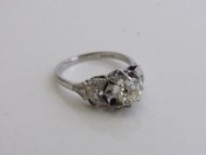 Platinum & diamond ring set with a single diamond, approx 1ct, about 6mm diameter with baguette &