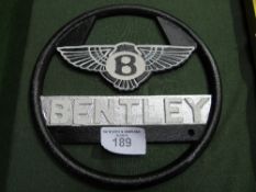 Champion Spark Plugs enamel sign & Bentley enamel steering wheel. Estimate £40-60