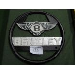 Champion Spark Plugs enamel sign & Bentley enamel steering wheel. Estimate £40-60