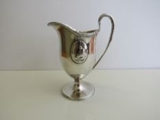 Georgian ewer shaped silver jug with oval figuritine plaques & leaf decoration, London, weight 5.