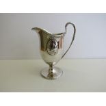 Georgian ewer shaped silver jug with oval figuritine plaques & leaf decoration, London, weight 5.