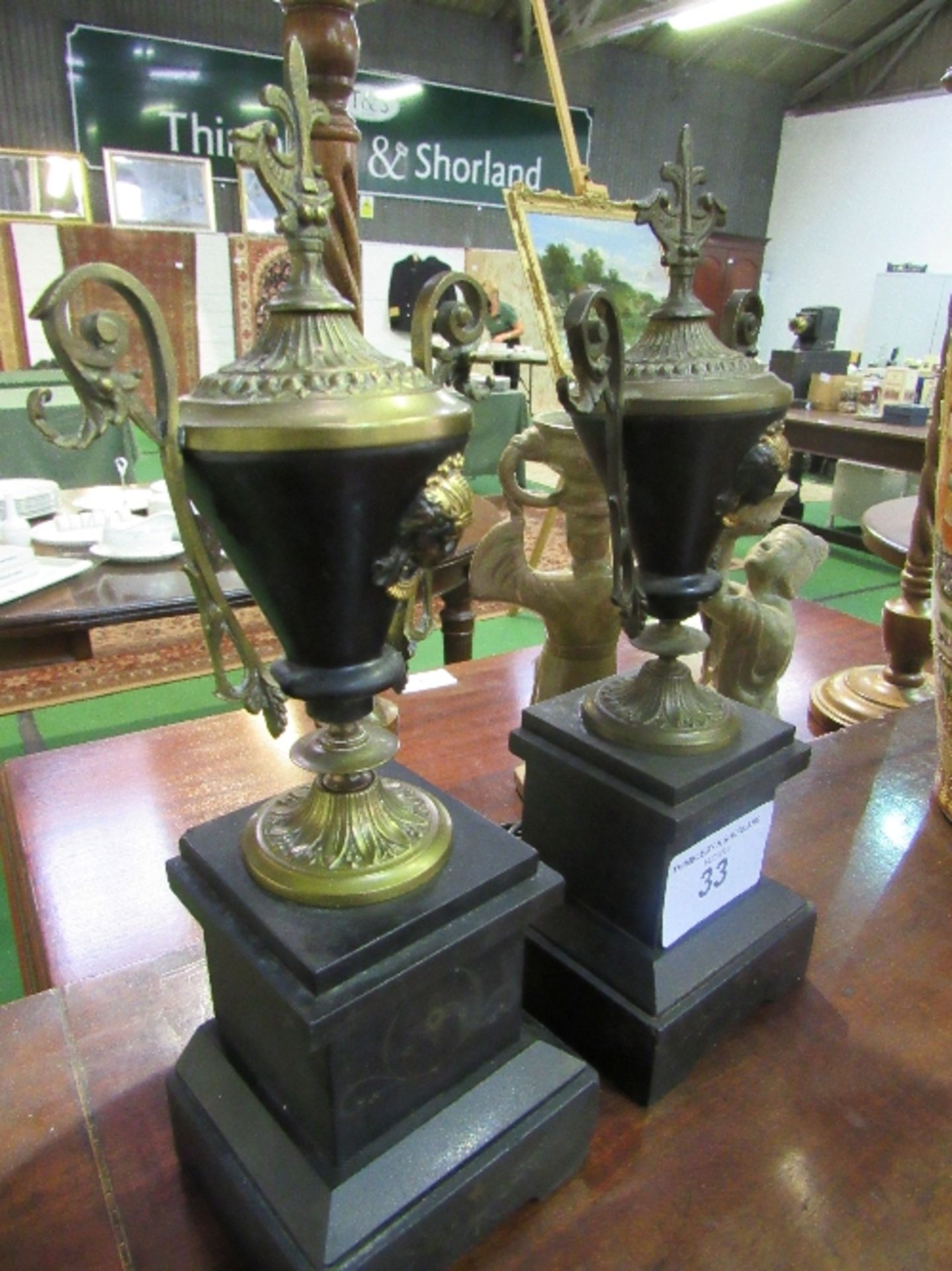 Pair of brass Grecian vase style garnitures with scrolled handles on polished black slate bases, - Image 3 of 3