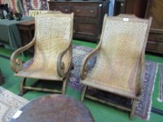 A pair of Indonesian hardwood & cane 'lazy chairs'. Estimate £80-100