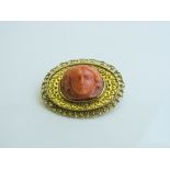 Victorian 15ct gold brooch with coral coloured woman's head, total weight 10gms. Estimate £80-100