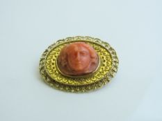 Victorian 15ct gold brooch with coral coloured woman's head, total weight 10gms. Estimate £80-100