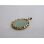 9ct gold circular jade pendant, diameter 2.5cms. Estimate £60-80