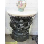 Console table of 3 bronzed cherubs round classic column with marble-effect top, 77 x 38 x 101cms.