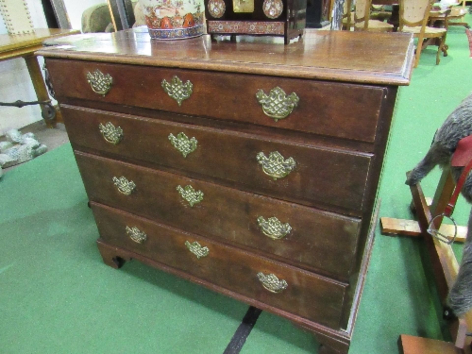 Georgian oak chest of 4 graduated drawers with ornate brass handles & escutcheons on bracket feet,