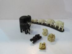 Family of carved bone elephants; carved ebony elephants; 3 Netsukis & a small carved figure.