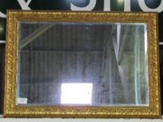 Decorative gilt framed bevel-edged wall mirror, 76 x 104cms. Estimate £20-40