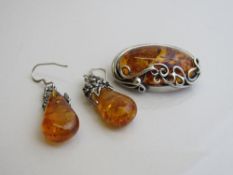 Silver mounted amber brooch & a pair of amber drop earrings. Estimate £30-50