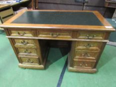 An early 20th century oak & mahogany desk with panelled sides & black tooled leather top