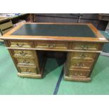 An early 20th century oak & mahogany desk with panelled sides & black tooled leather top