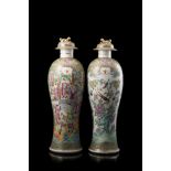 A pair of Cantonese Famille Rose baluster vases decorated with figures and floral motifs (defects)