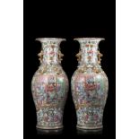 A pair of Cantonese Famille Rose vases decorated with figures in interior scenes and floral