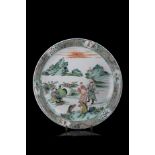 A large Famille Verte dish decorated with figures and horses in a mountain landscapeChina, 20th