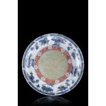 A blue and white and iron red enamelled dish, the centre with a celadon glaze, decorated with floral