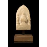 A white stone sculpture of a Buddha accompanied by two attendants, wood baseChina, 19th century(h.